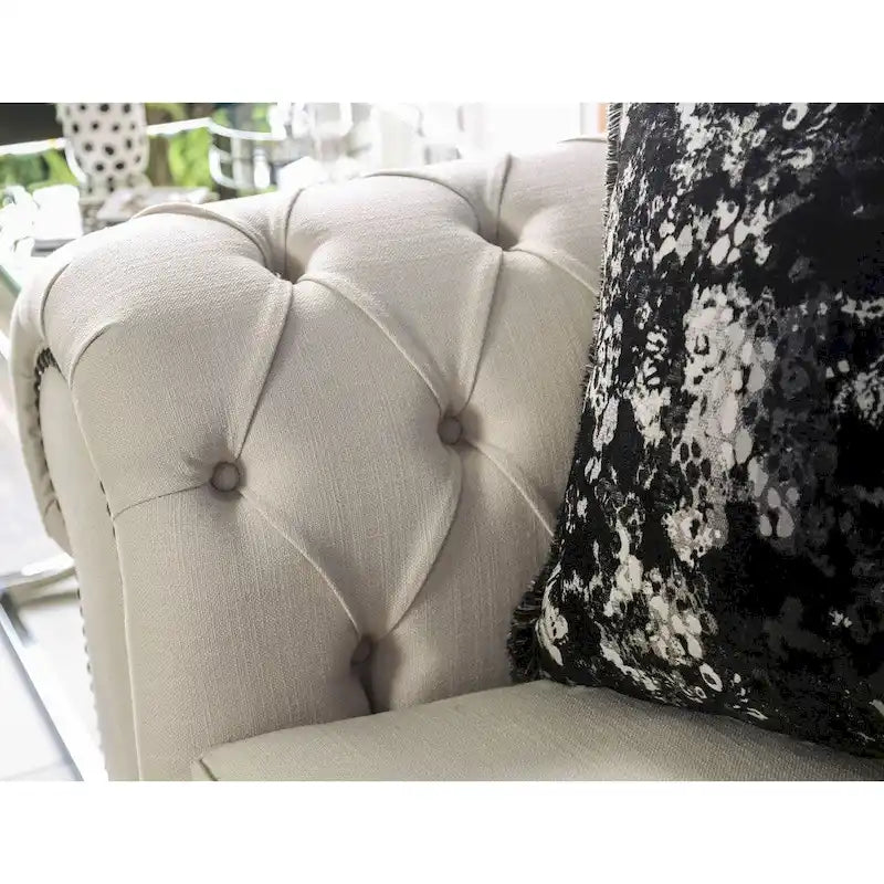 Canapé capitonné en tissu beige avec garniture cloutée
