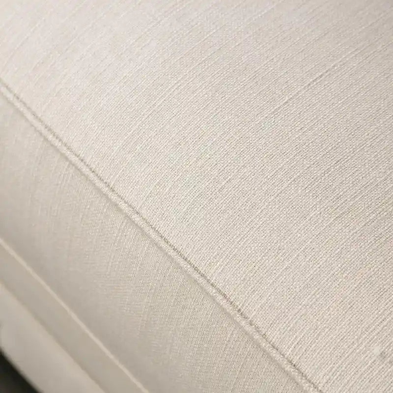 Canapé capitonné en tissu beige avec garniture cloutée